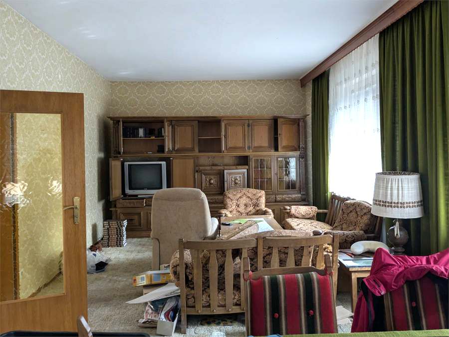 Entrümpelung in Darmstadt vorher: Ein vollgestelltes Wohnzimmer mit alten Möbeln ist zu sehen.