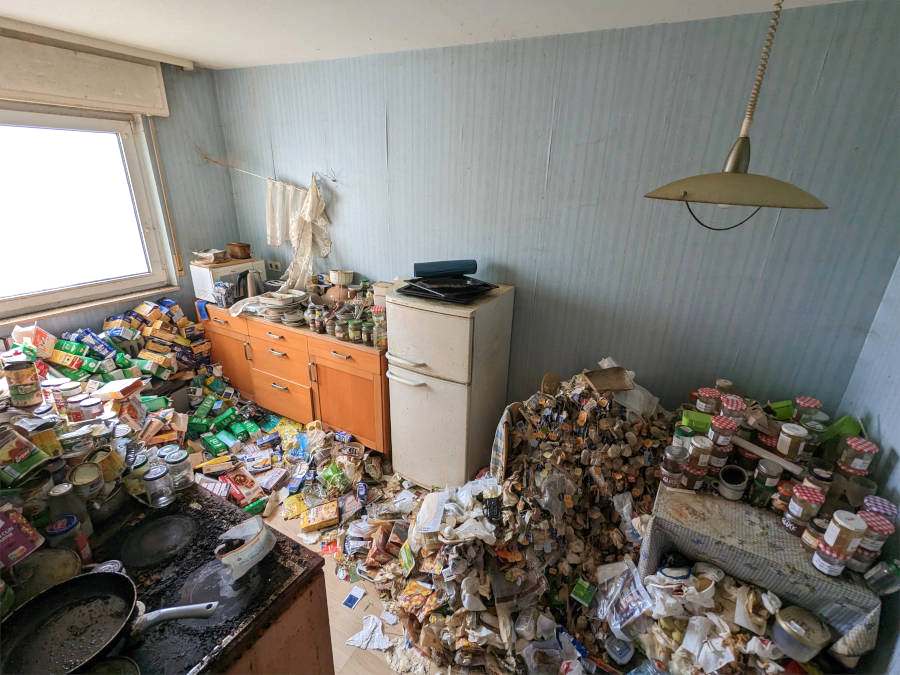 Entrümpelung in Frankfurt: Eine Messie-Küche ist zu sehen, vollgestellt mit dreckigem Geschirr, Essensresten und Müll.